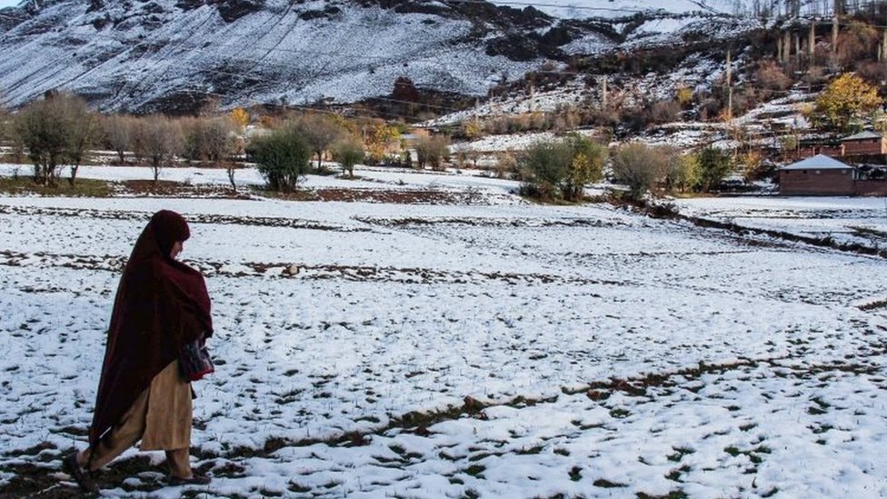 Пострадавший от землетрясения идет по заснеженному полю в деревне Чарун Вир в долине Читрал, Пакистан (ноябрь 2015 г.)