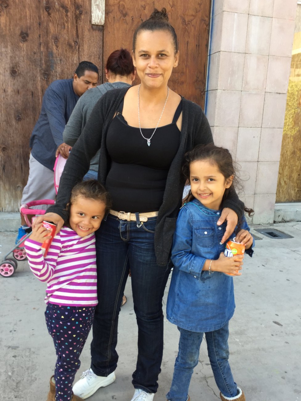 Женщина и двое детей позируют для фото возле границы США и Мексики, 29 апреля 2018 г.