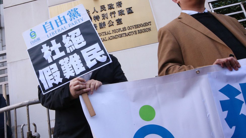 香港建制派自由黨黨員到中聯辦舉起「杜絶假難民」標語牌請願要求北京替香港退出聯合國《禁止酷刑公約》（資料圖片）