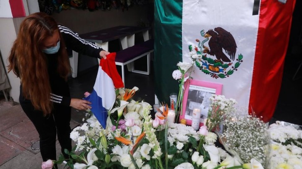 Сотрудник ставит французский флаг на алтарь возле ресторана, принадлежащего французскому бизнесмену Батисту Жаку Даниэлю Лорману после того, как он был найден убитым в Мехико, Мексика, 30 ноября 2020 г.