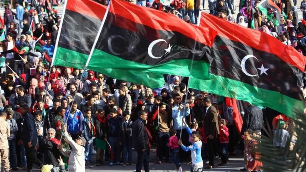 متظاهرون يحملون العلم الليبي