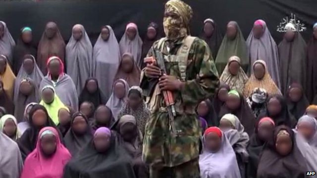 A masked gunman stands over the girls in the video