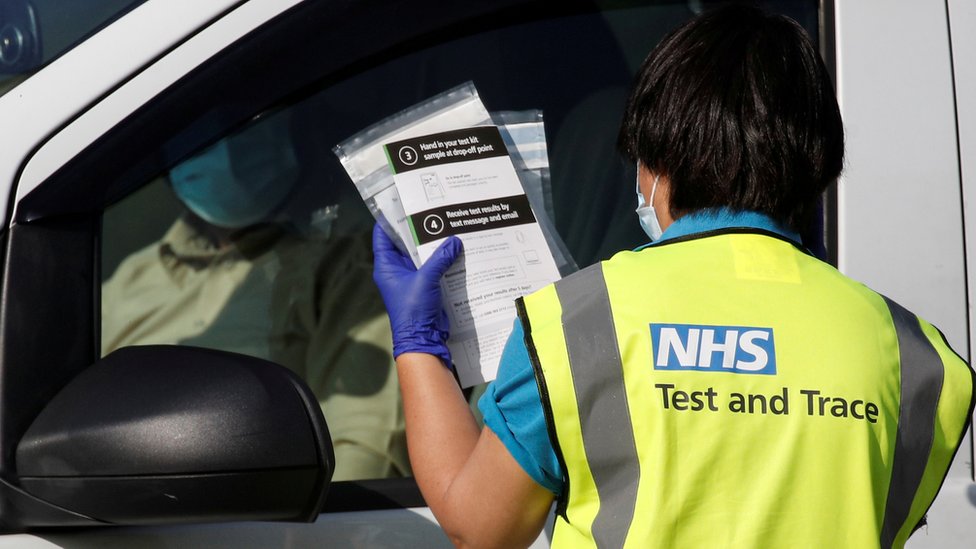 Специалист по тестированию и отслеживанию NHS проводит тест на коронавирус кому-то, кто ждет в автомобиле