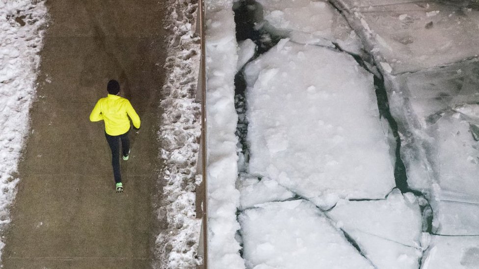 Personas corriendo junto a bloques de hielo en Chicago