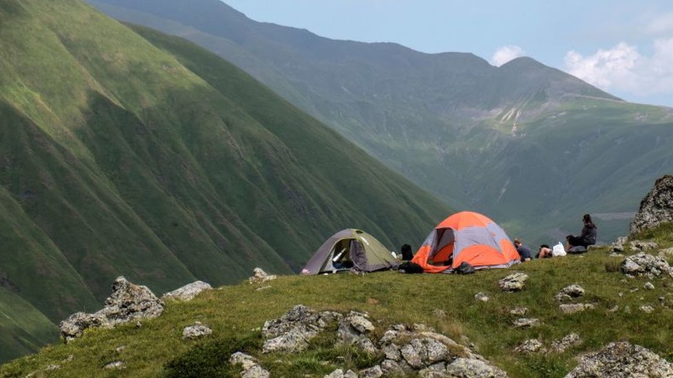 La exposición a los ciclos de luz naturales puede modificar el reloj biológico. Personas acampando al aire libre.