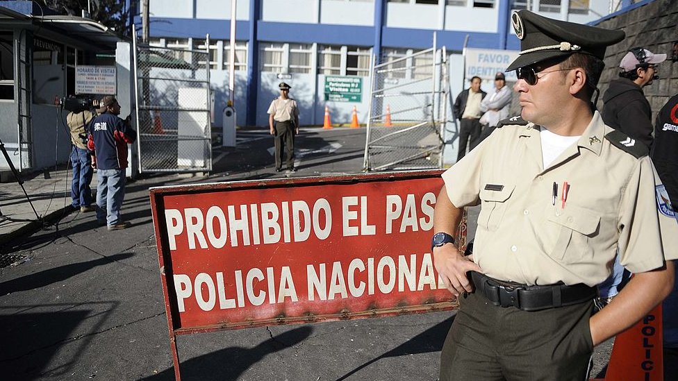 Un policía vigila la entrada a un edificio policial en Quito.