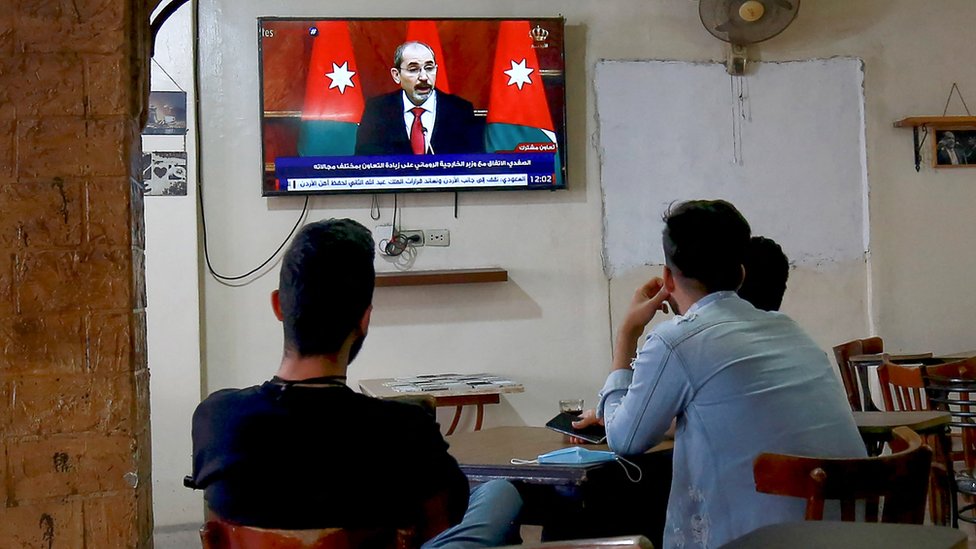 Warga Yordania menonton siaran berita di sebuah kafe di ibu kota, Amman.