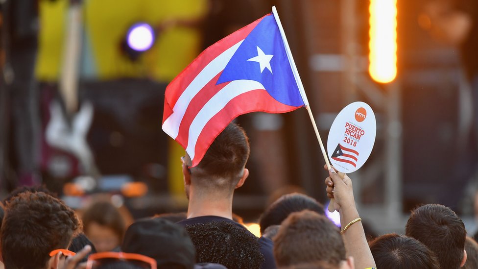 Grupo de personas y una bandera de Puerto Rico