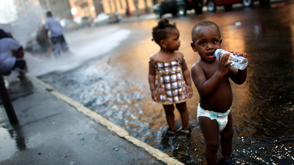 Niños jugando con agua en la calle durante una ola de calor