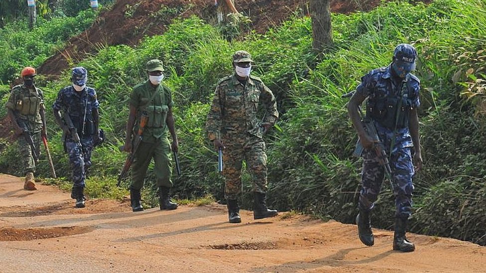 Ugandan military forces and police patrol a potholed road in the capital Kampala a day ahead of the presidential elections in Uganda 13 January 2021.