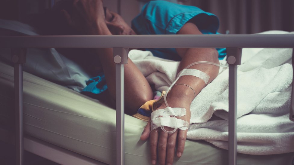 Mujer tumbada en cama de hospital