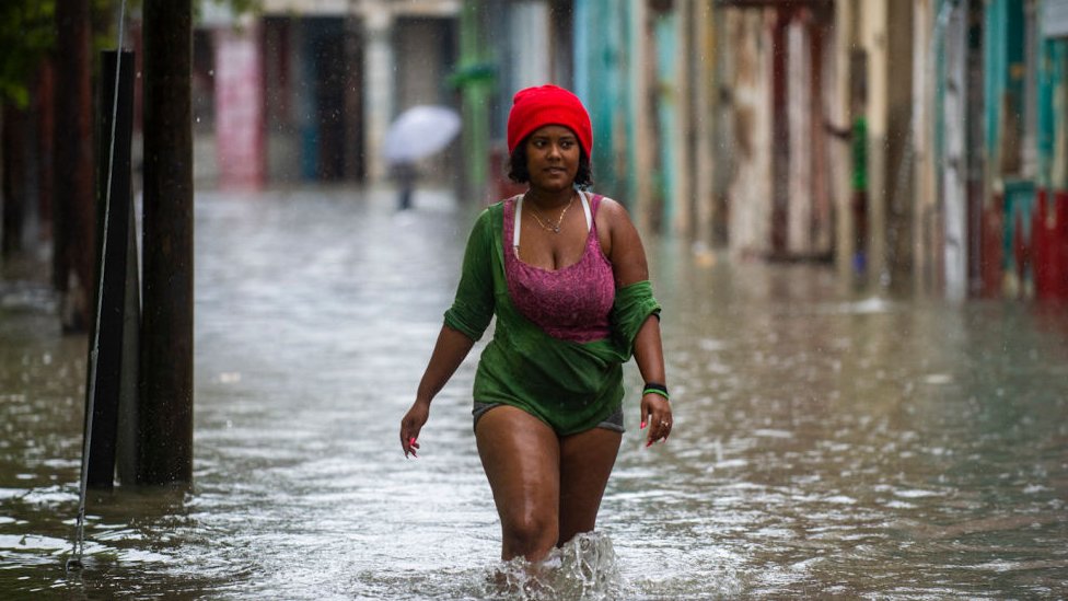 Una mujer camina en una calle inundada de La Habana
