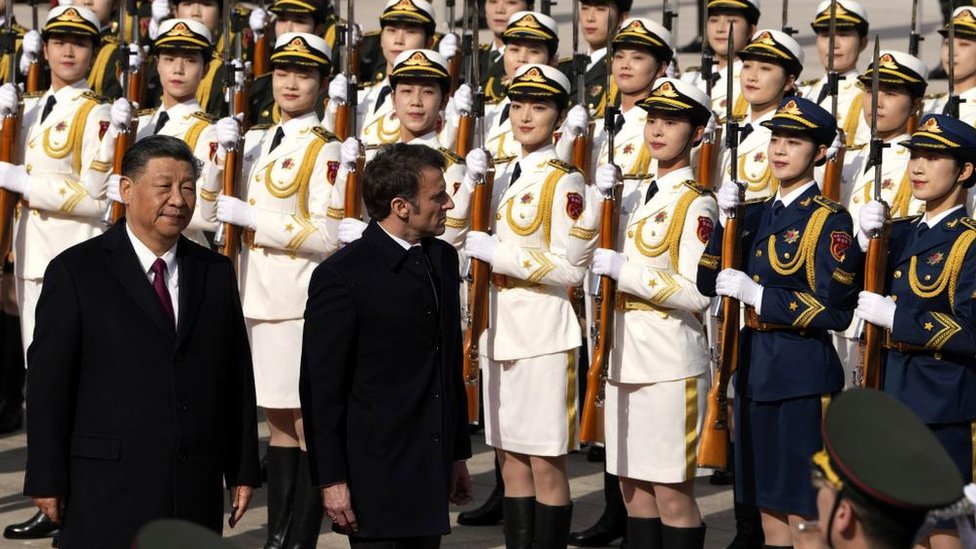 الرئيس الفرنسي إيمانويل ماكرون يستعرض حرس الشرف مع الرئيس الصيني شي جنبنغ خارج قاعة الشعب الكبرى في بكين