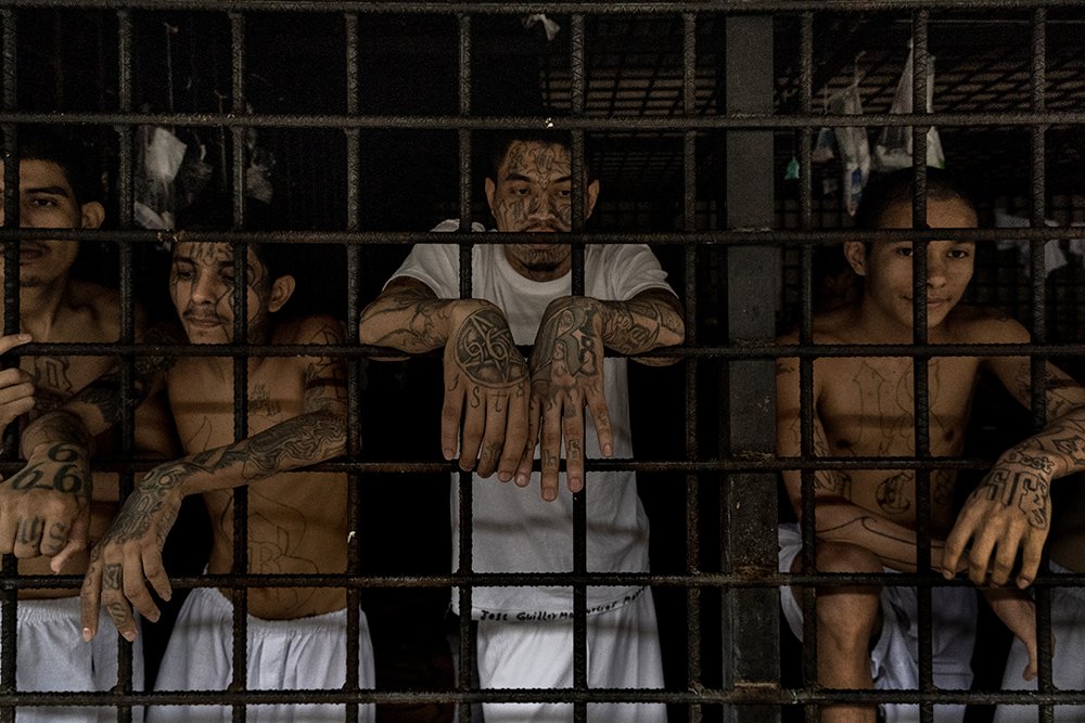 Tattooed gang members stand in their holding cells at Bartolinas Policiales de Lourdes, Colon, San Salvador. 28 September 2019
