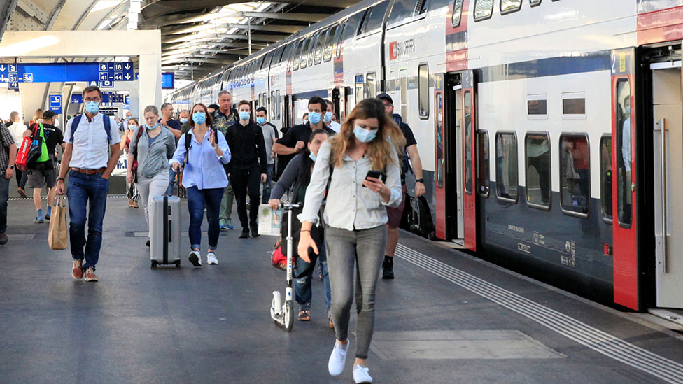 Пассажиры надевают защитные маски, покидая поезд швейцарского железнодорожного оператора SBB, поскольку вспышка коронавирусной болезни (COVID-19) продолжается, на центральном вокзале Hauptbahnhof в Цюрихе, Швейцария, 6 июля 2020 г.