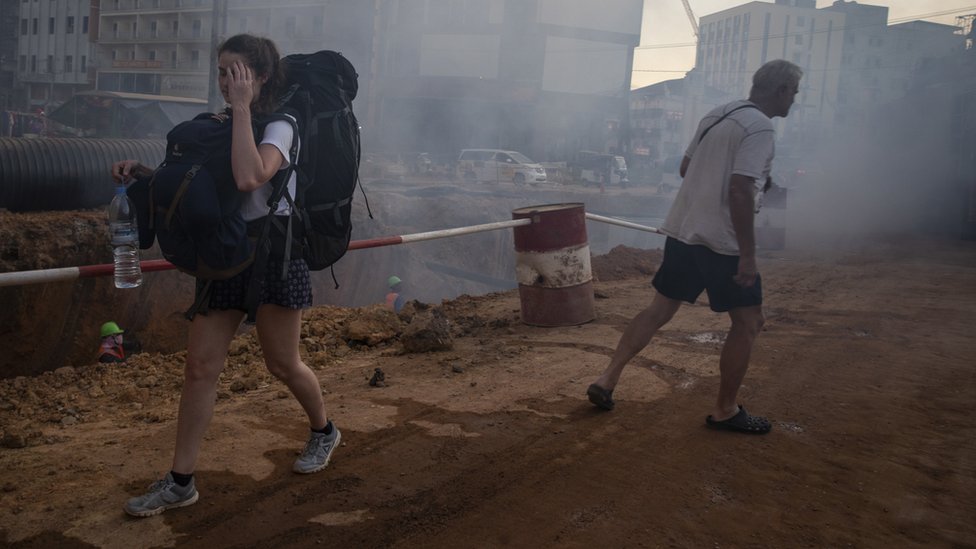 柬埔寨西哈努克市（西港）一位西方女性背包客走過一片沙塵滾滾的工地（資料圖片）