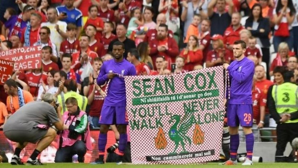 Игроки Ливерпуля с баннером Шона Кокса