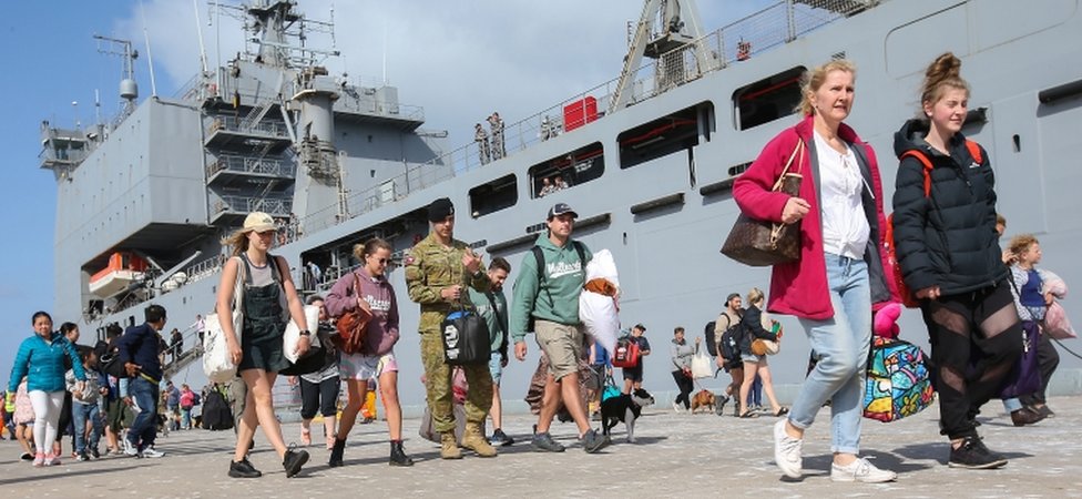 Эвакуированные покидают HMAS Choules в порту Гастингса, Виктория