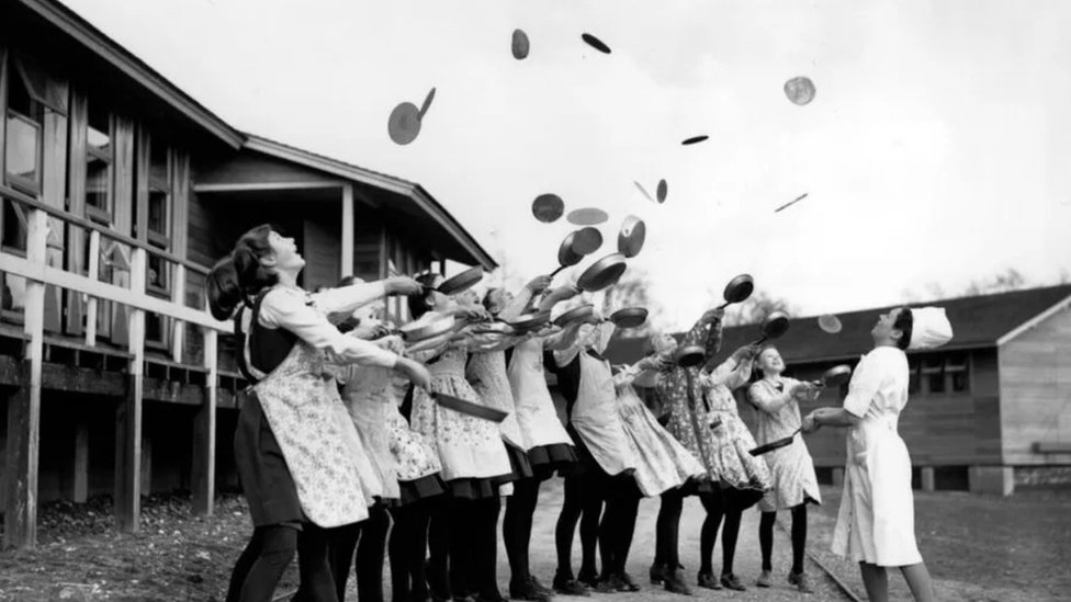 صورة في فبراير/شباط 1941: الاحتفال بثلاثاء المرافع برفع الفطائر في الهواء بصورة تقليدية أثناء تجهيزه في أيرلندا الشمالية