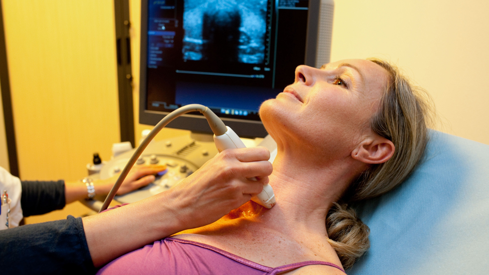 Woman undergoing a thyroid scan