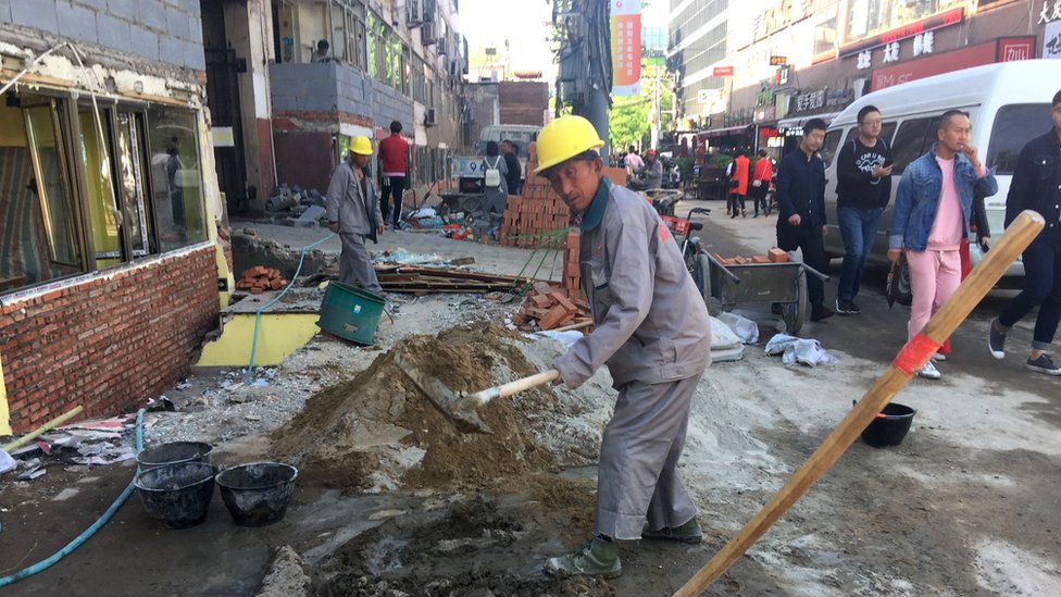 Пекинские рабочие сносят небольшие магазины
