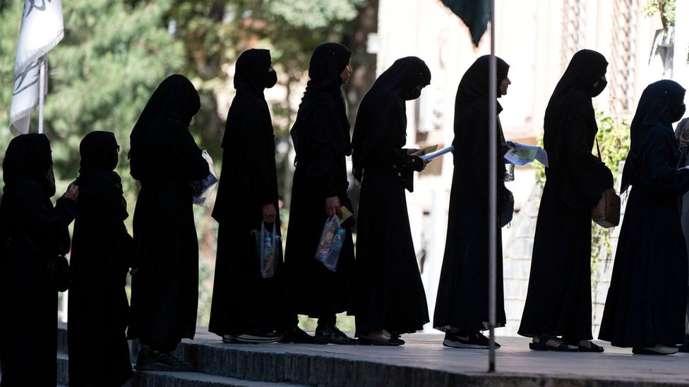 Afghan female students stand in a queue after they arrive for entrance exams at Kabul University in Kabul on October 13, 2022.
