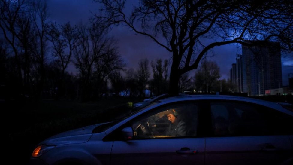 امرأة أوكرانية تجلس في سيارة بعد انقطاع الأنوار في كييف
