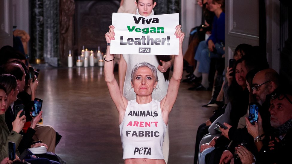 Peta aktivistkinja koja nosi majicu sa porukom "životinje nisu materijal" i znak "živela veganska koža" na Nedelji mode u Parizu
