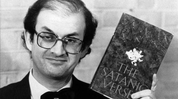 Salman Rushdie con su libro "Los versos satánicos"