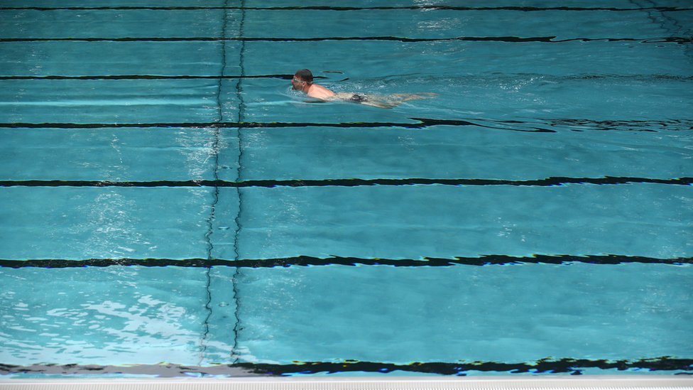 Мужчина плавает в бассейне