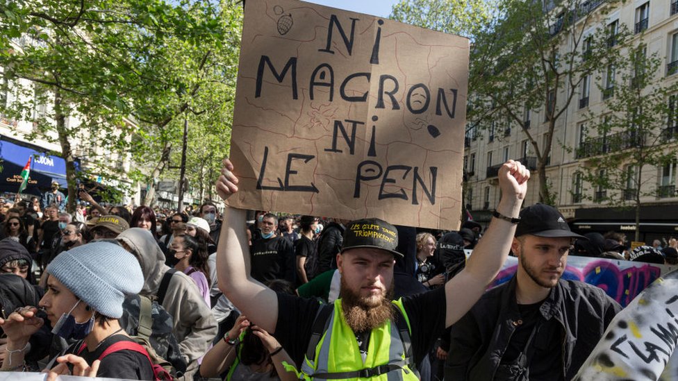 A protester holds a sign that says "Neither Macron or Le Pen" at a demonstration against the rise of the far-right in French politics, on April 16, 2022 in Paris,