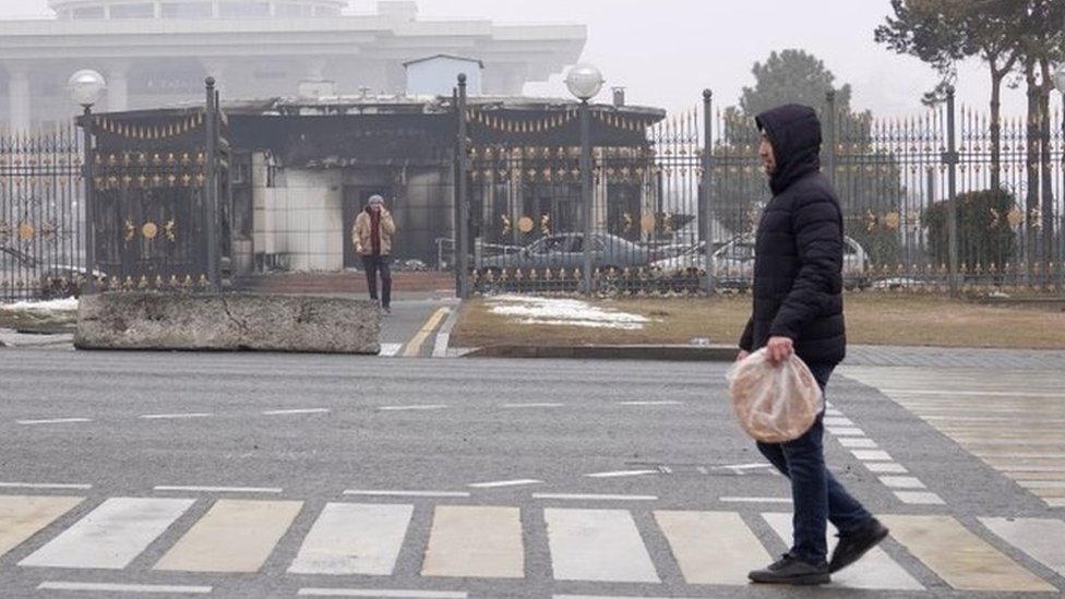 一名男子走過阿拉木圖被燒燬的政府大樓。