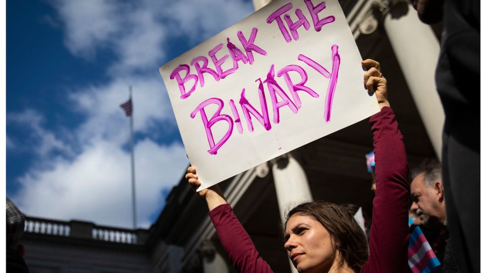 Mujer protesta con un cartel a favor de la comunidad trans