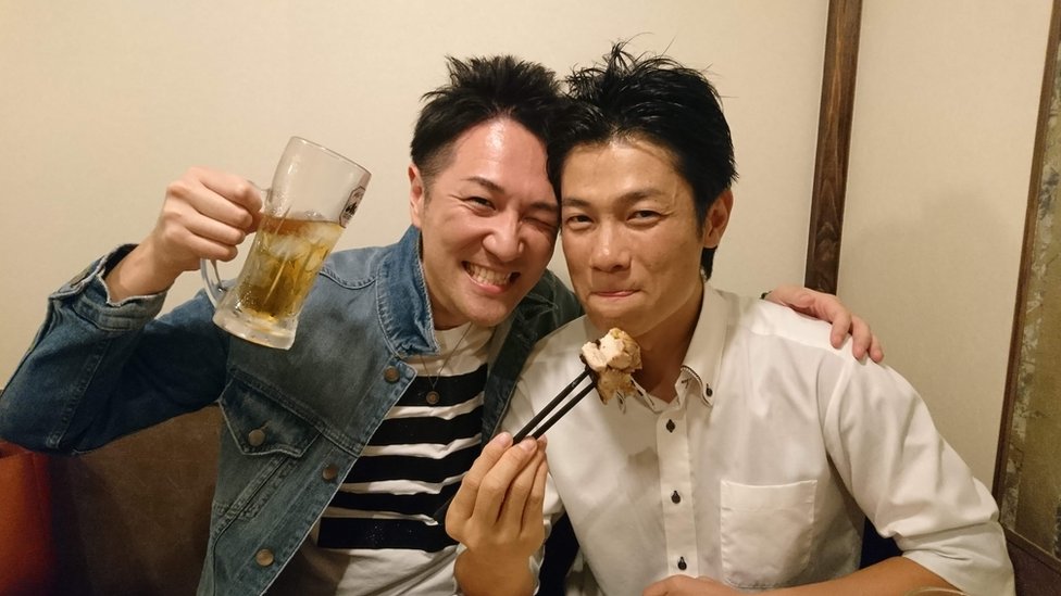 Yuichi Ishii brinda con un vaso de cerveza cerca de un amigo