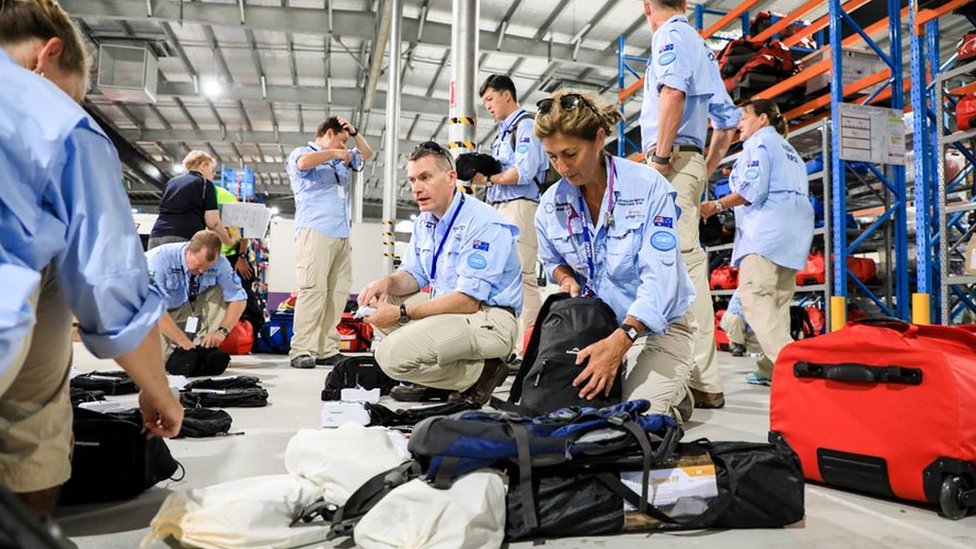 Австралийская медицинская бригада пакует чемоданы в ангаре перед отъездом на остров Рождества