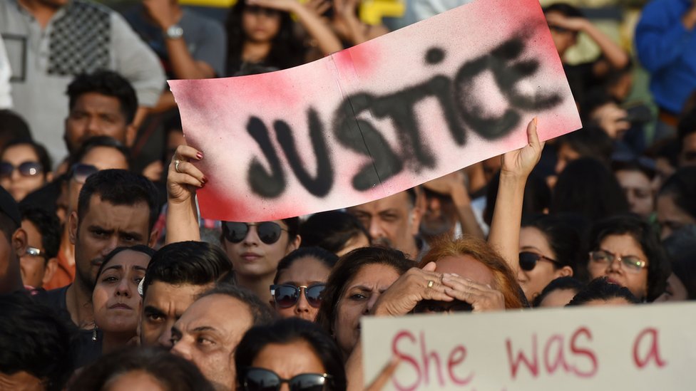 Индийские демонстранты держат плакат "Справедливость" во время акции протеста в поддержку жертв изнасилования.