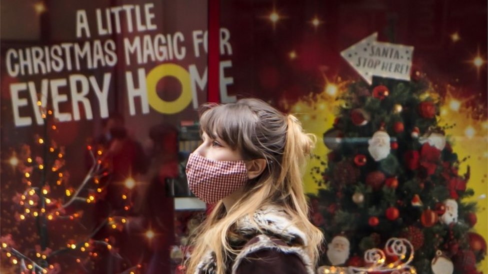 Женщина проходит мимо рождественского магазина