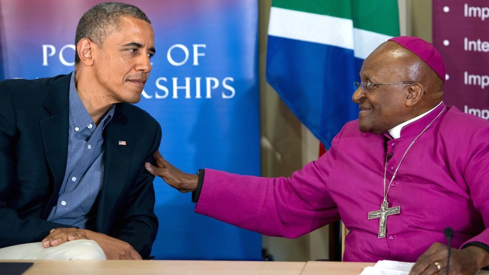 Then-US President Barack Obama sits with South Africa's Nobel peace laureate Archbishop Desmond Tutu following a tour of the Desmond Tutu HIV Foundation Youth Centre in Cape Town, South Africa, 30 June 2013