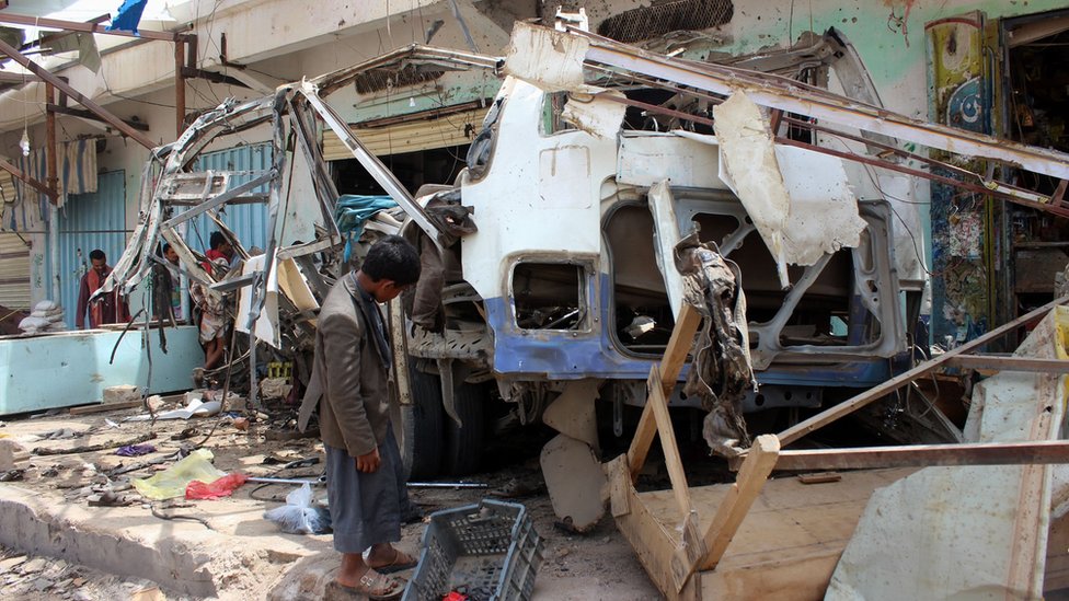 Мужчина осматривает автобус, разрушенный в результате авиаудара коалиции под руководством Саудовской Аравии в Дахайане, провинция Саада, Йемен (10 августа 2018 г.)