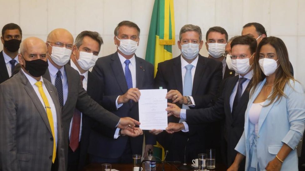 Presidente Jair Bolsonaro rodeado por parlamentares durante entrega da MP do Auxílio Brasil
