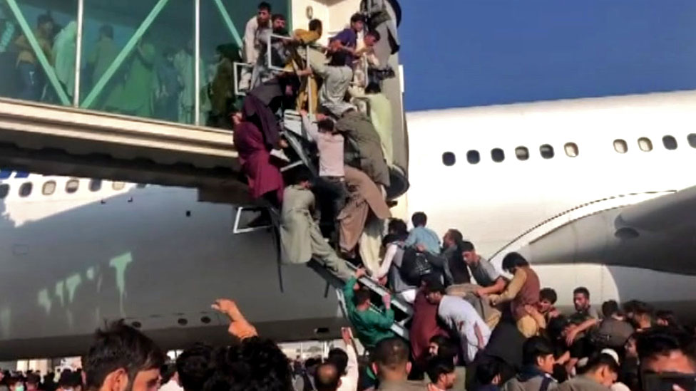 People climbing on to plane at Kabul airport