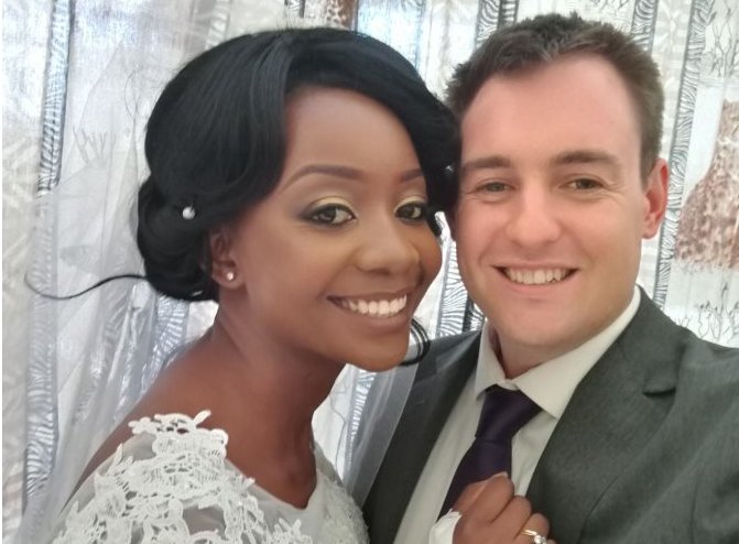 Zanele y Jamie sonríen a la cámara el día de su boda.