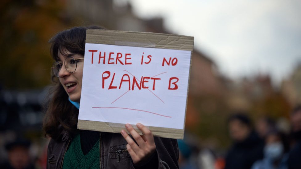 A young woman holds a sheet 'There is no Planet B' during a climate march in Toulouse, France, in 2021