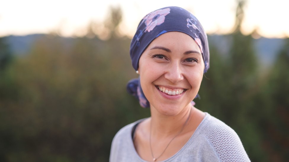 Mujer sonriente con un pañuelo en la cabeza.