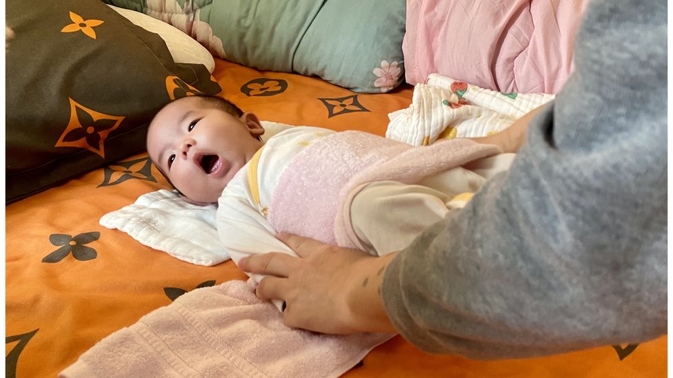 Baby Heng Heng lies on a mat