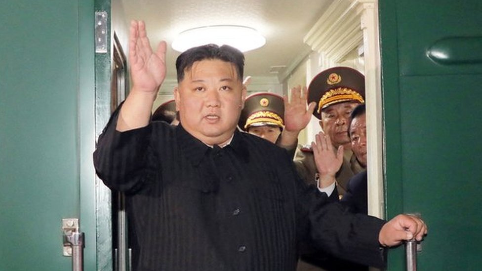 Mr Kim waves from his private train before departing Pyongyang, North Korea, for Russia