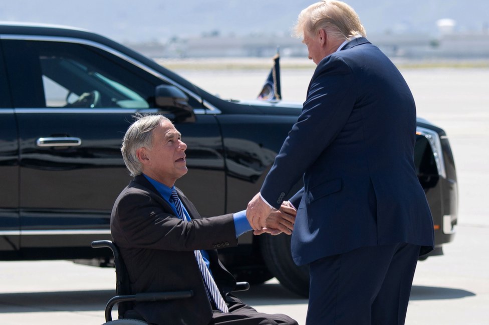 US President Donald Trump (R) greets Texas Governor Greg Abbott in El Paso, 7 August