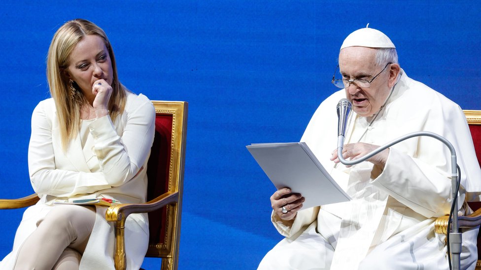 Pope Francis reading his speech alongside and Italian Prime Minister Giorgia Meloni
