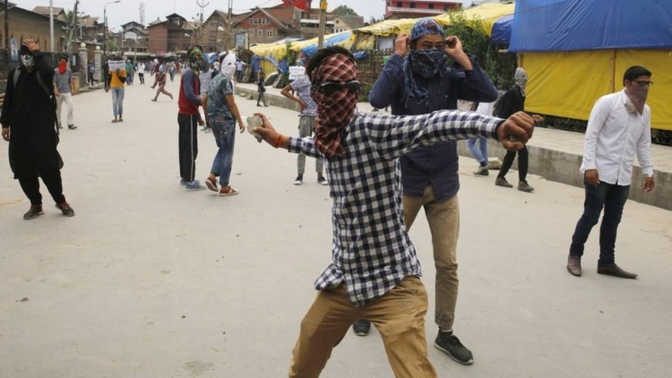 Кашмирский юноша бросает камень в индийскую полицию и военизированных формирований в Сринагаре (26 мая 2017 г.)