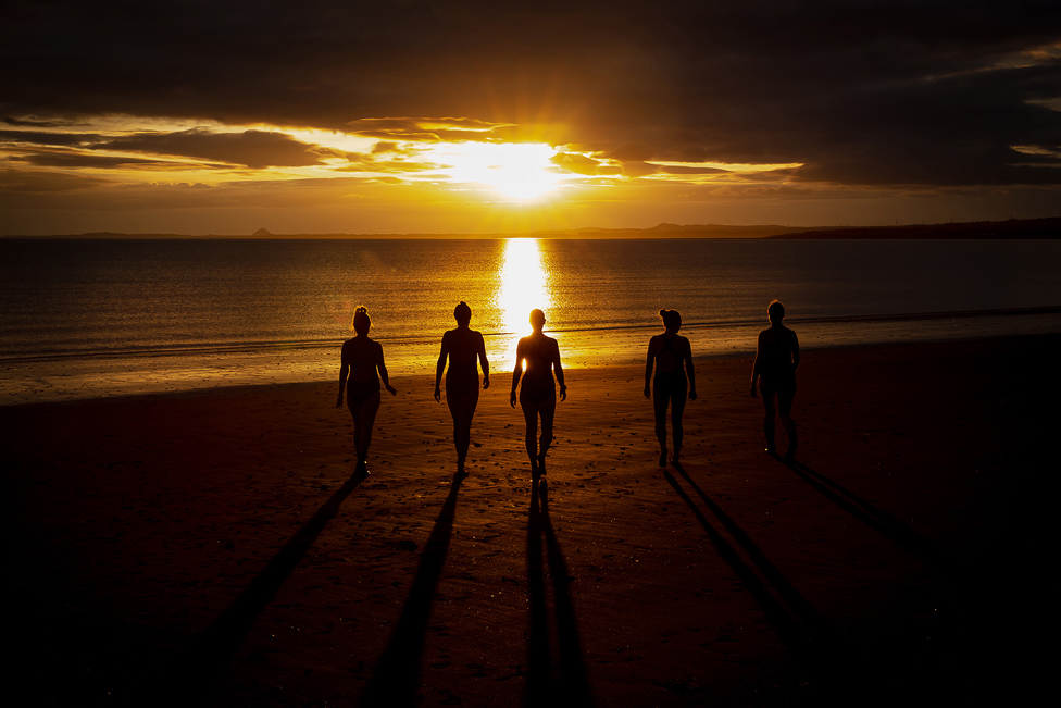 Gruppe von Menschen in der Schattenbild auf einem Strand